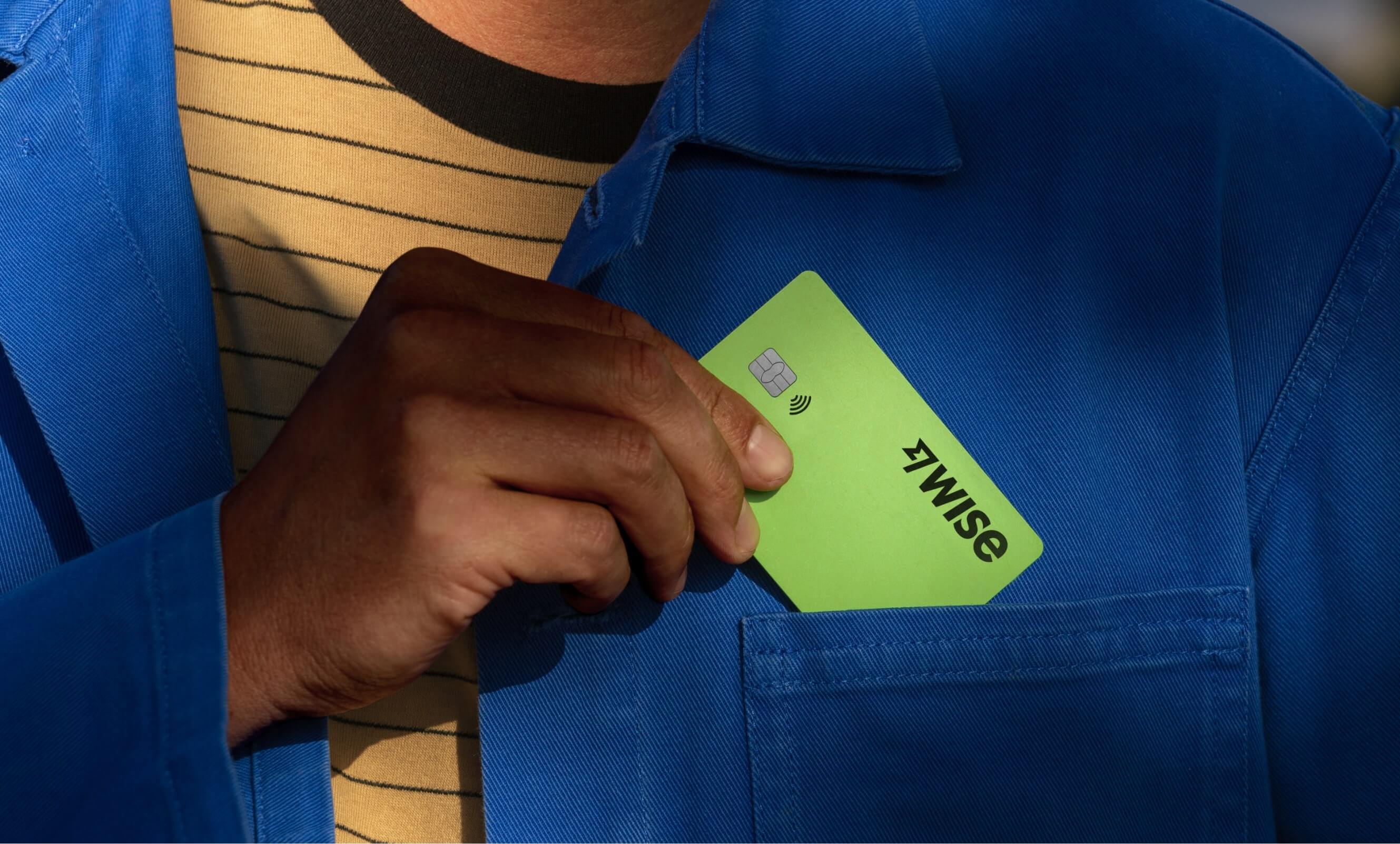 Una persona pone su tarjeta de Wise en el bolsillo de su abrigo