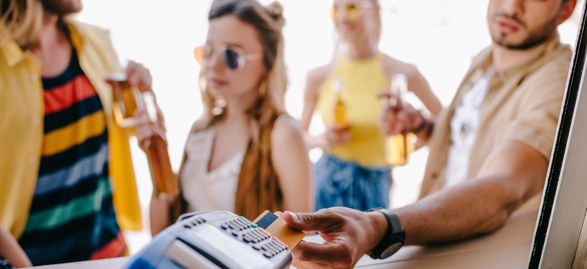 Group of people paying by card at a beach on a card terminal