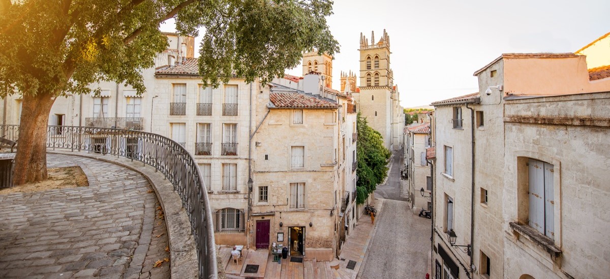 view of the street with saint Pierre cathedral at the old town of Montpellier city in the background