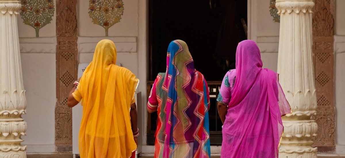 Three women in cokourful saris