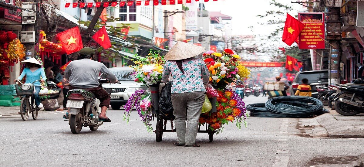 Vietnamese street vendor walking through market street