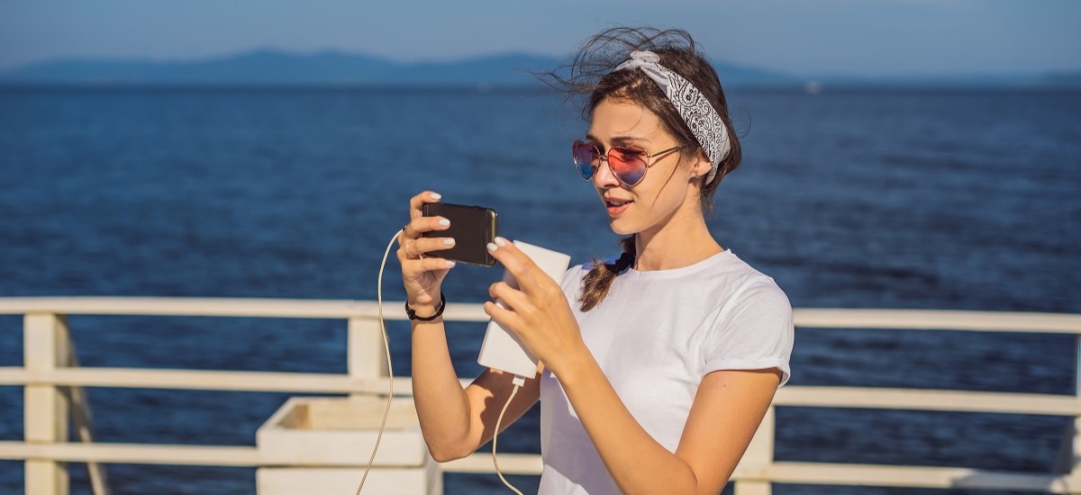 A woman using her phone on the deck of a cruise ship