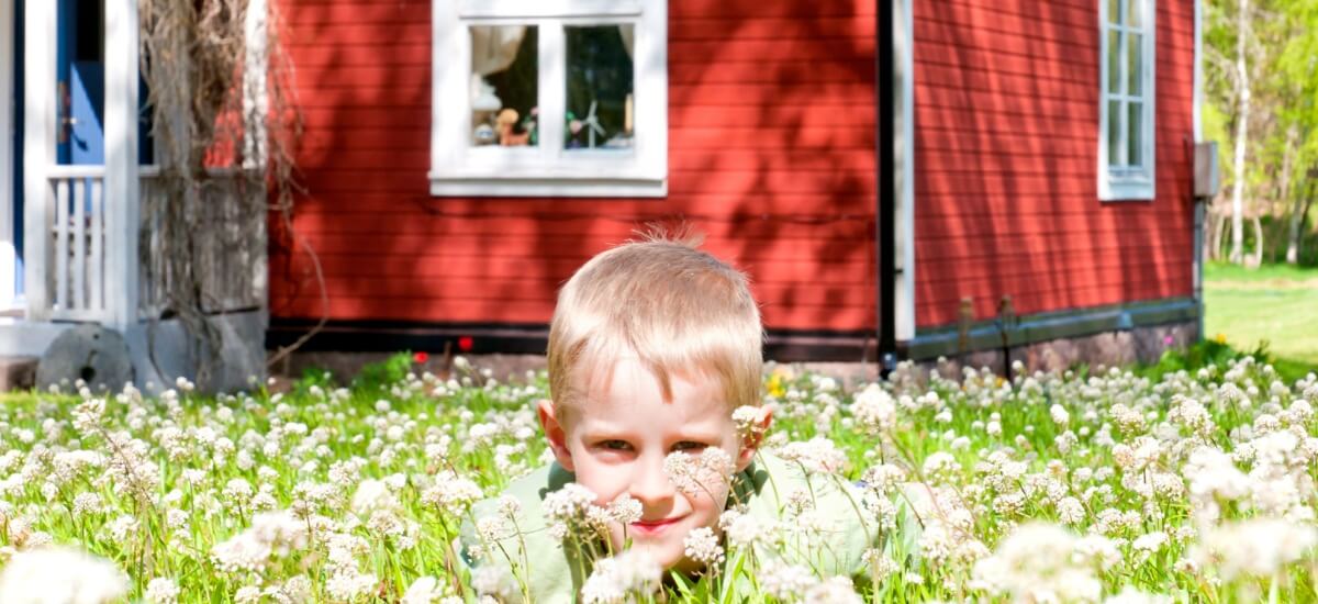 kid-hiding-in-grass-near-swedish-summer-house