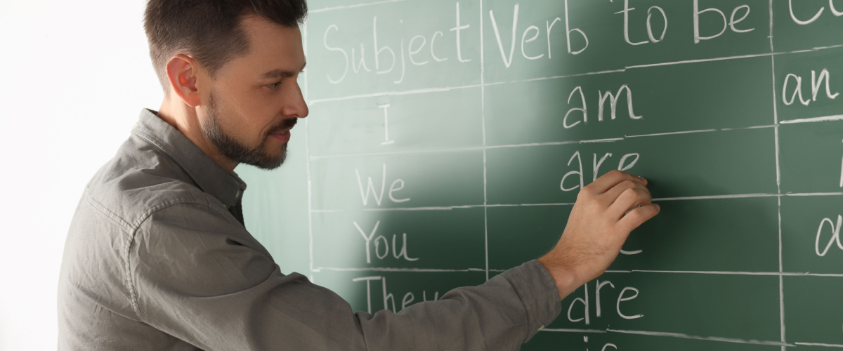 teacher-writing-grammar-with-chalk