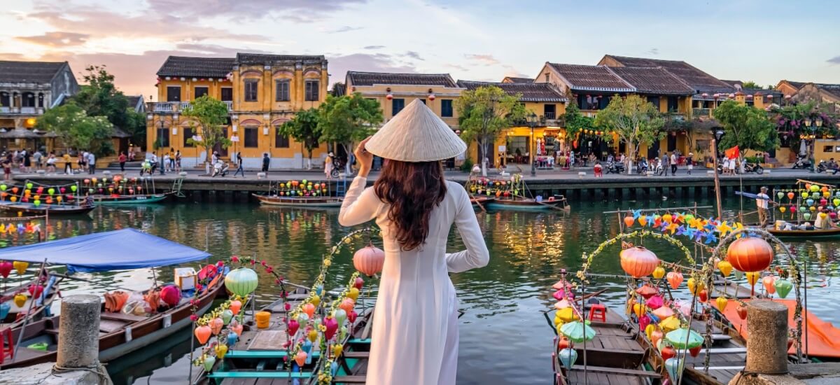 woman-standing-aside-a-river-overlooking-vietnam-city-houses