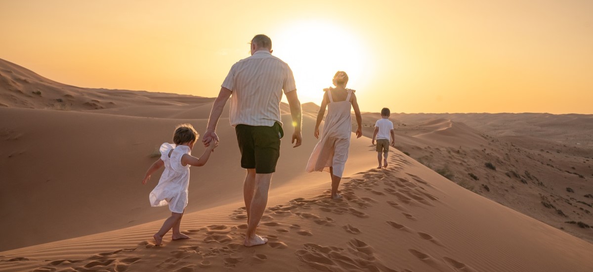 family walking through desert at sunset in Dubai