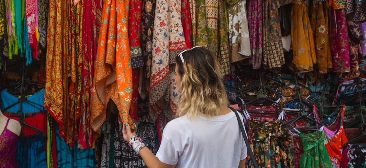 young woman browsing fabrics at market in Bali