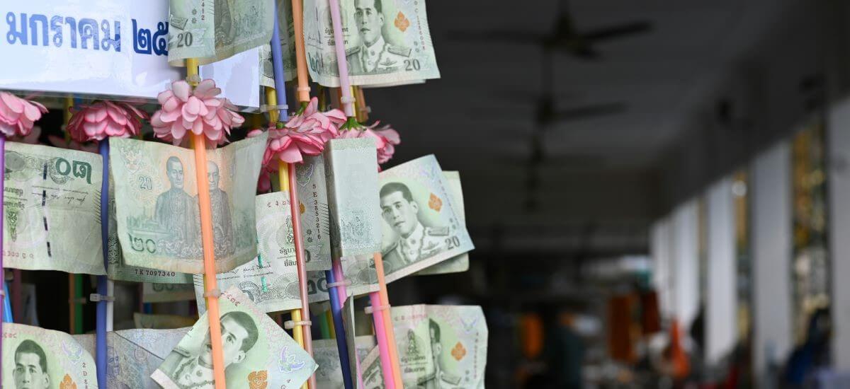 Thai bank notes pinned to Buddhist donation tree