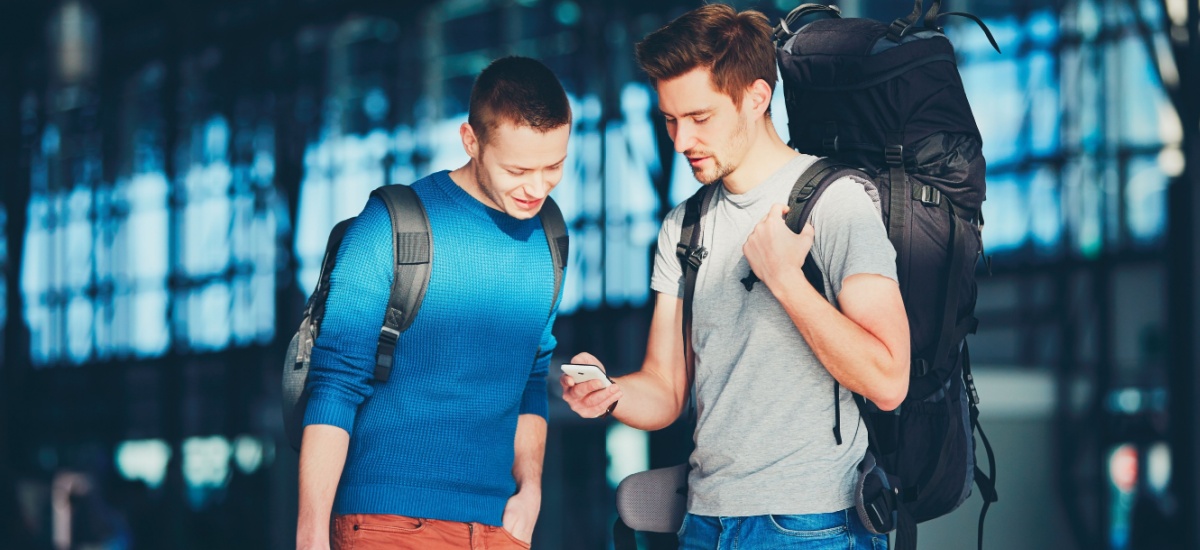 two-travellers-looking-at-phone-at-the-airport