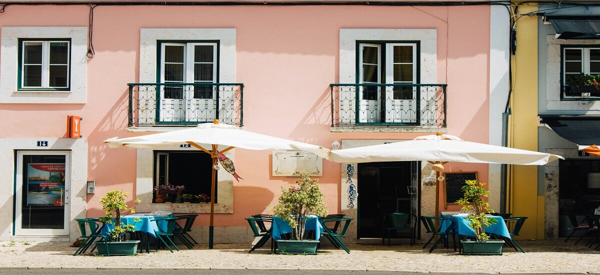 Small pink-walled tasca in Portugal with seating outside