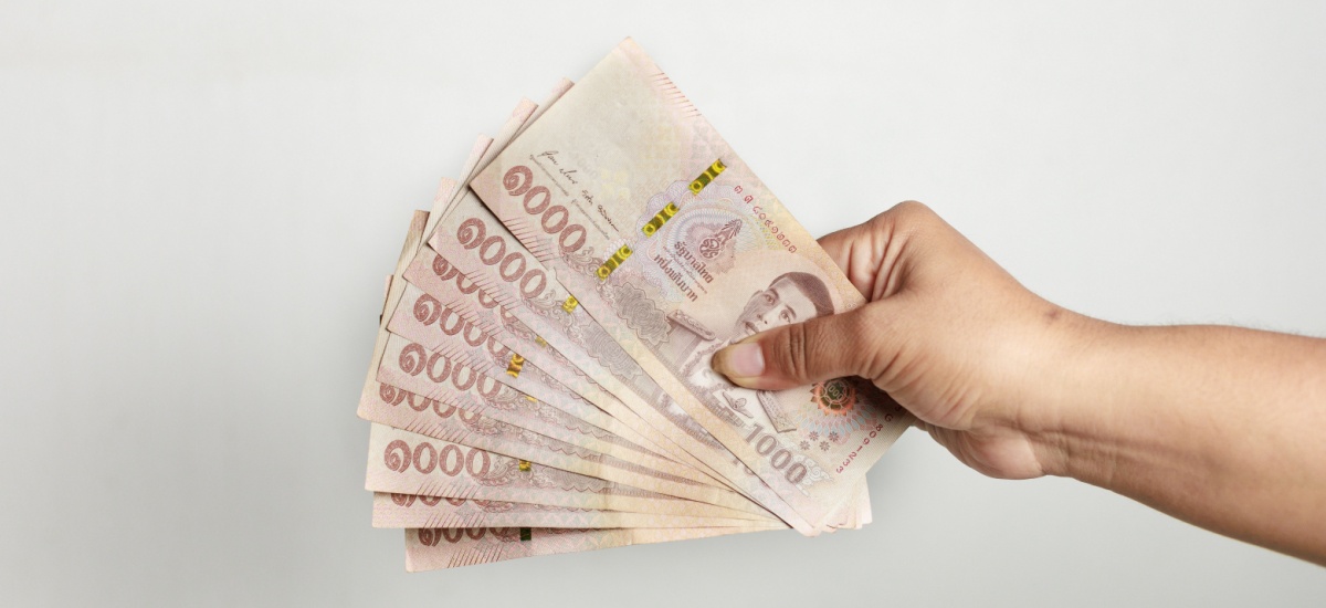 hand-holding-thai-baht-banknotes