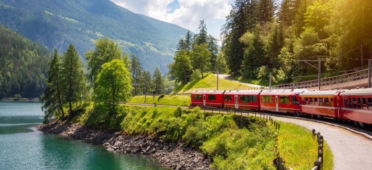 train-running-along-a-river-in-switzerland