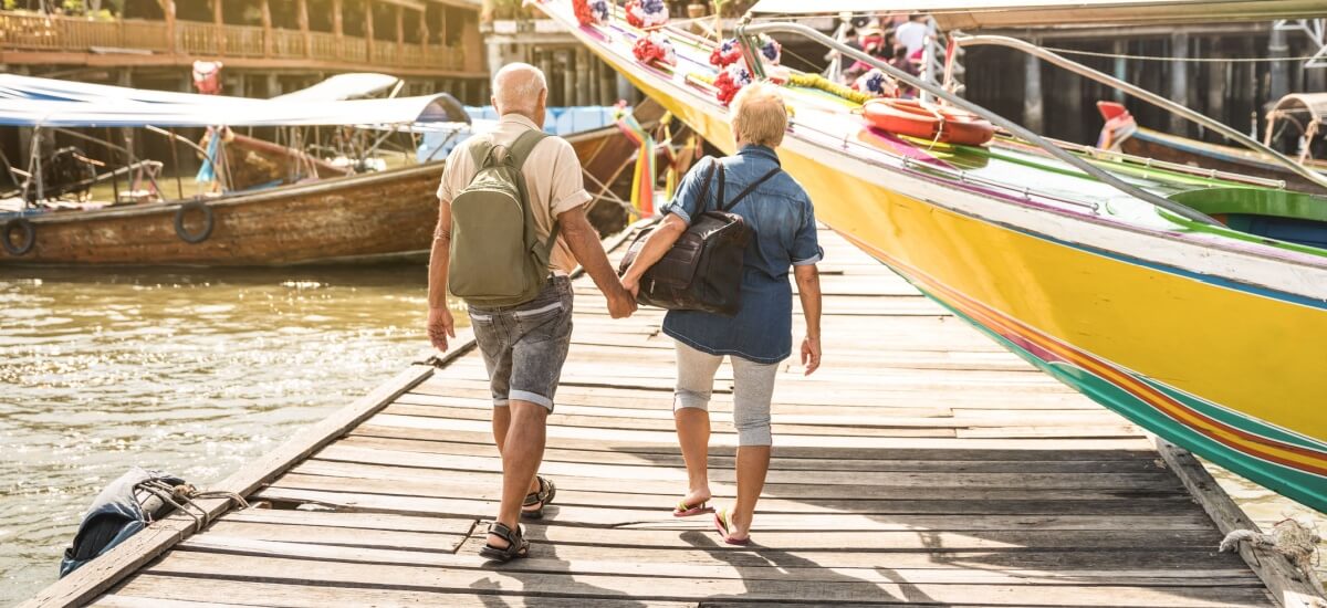 older-couple-holding-hands-walking-at-floating village
