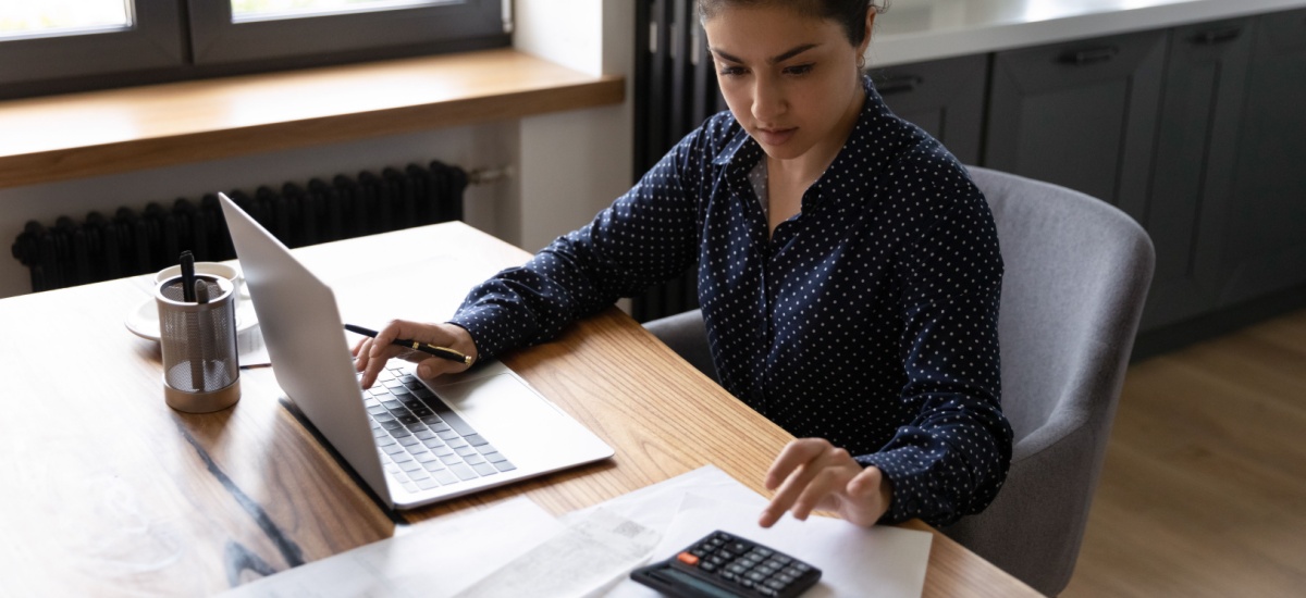 woman-calculating-costs-using-laptop-and-calculator