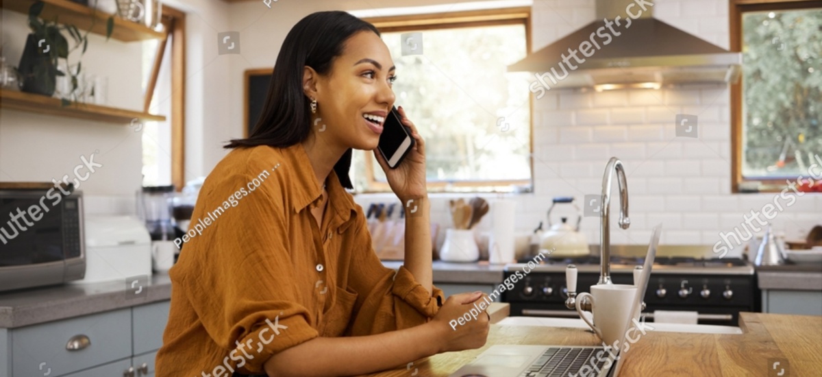 woman-making-a-phone-call-and-working-with-laptop