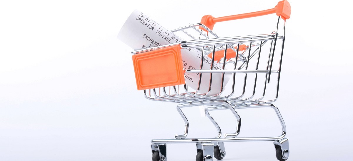 Shopping trollet with orange handle, with receipt inside on a white background