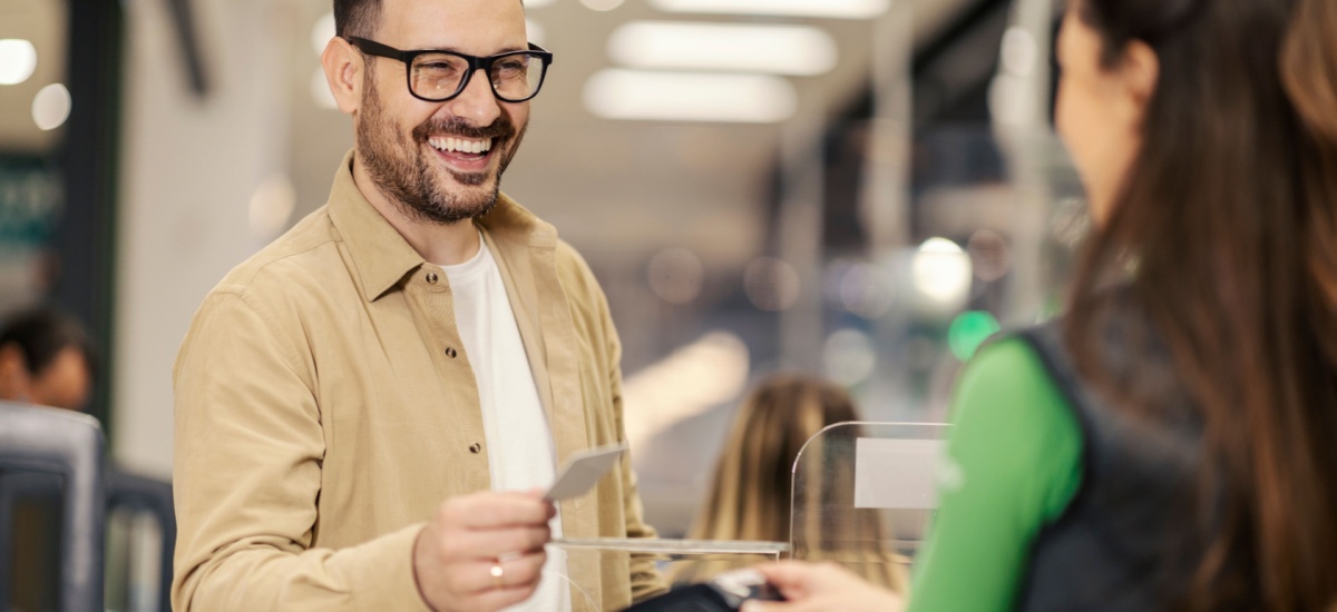 smiling-man-purchasing-with-credit-card