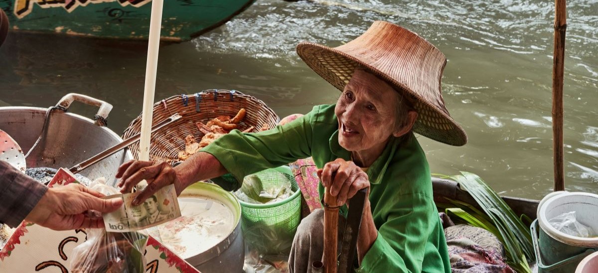 Thai boat vendor accepting cash