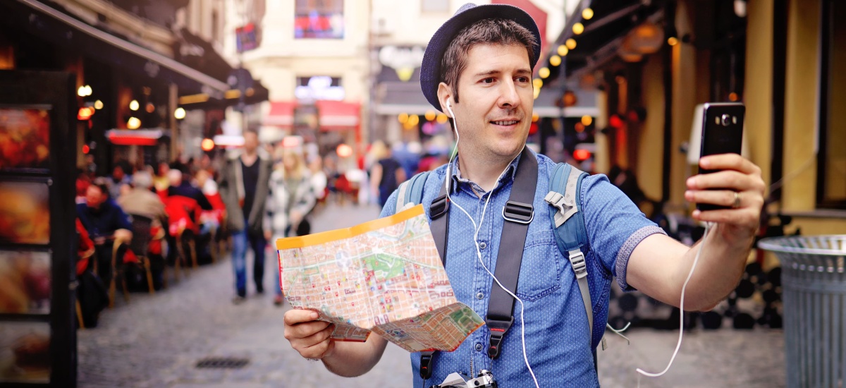 young-man-travelling-holding-a-map-and-a-phone