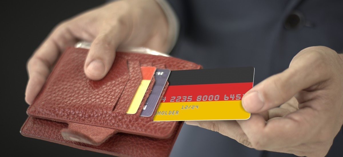 Close up of hand taking a bank card with German flag design out of wallet