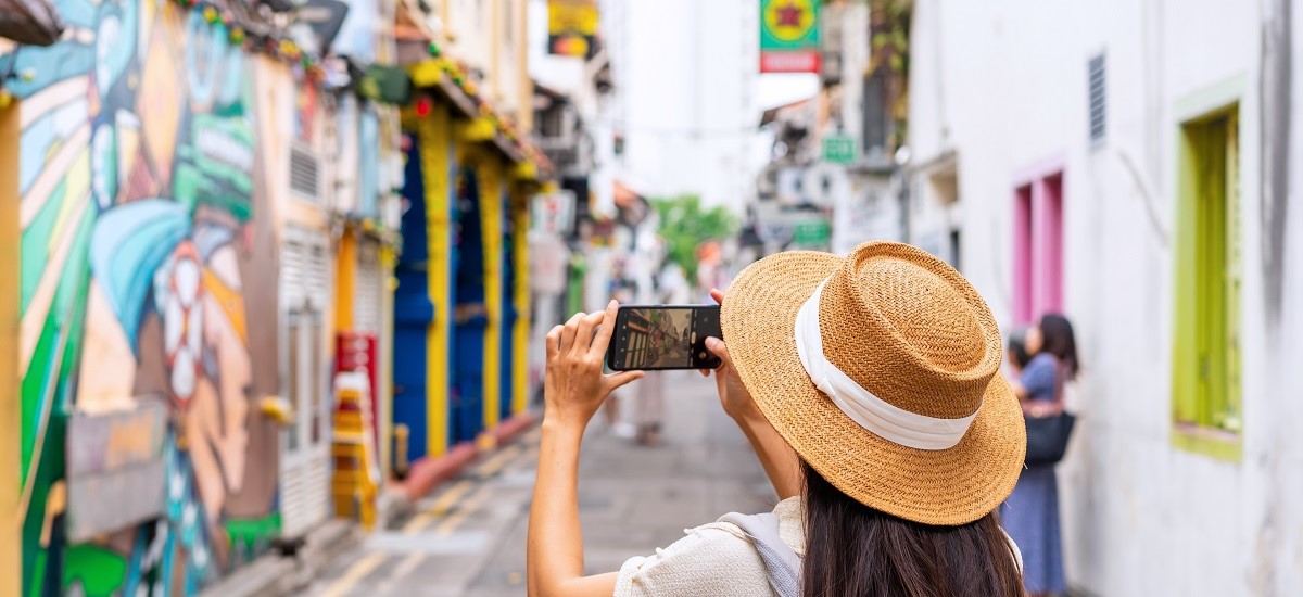 tourist taking a photgraph of graffiti in Haji Lane in Singapore