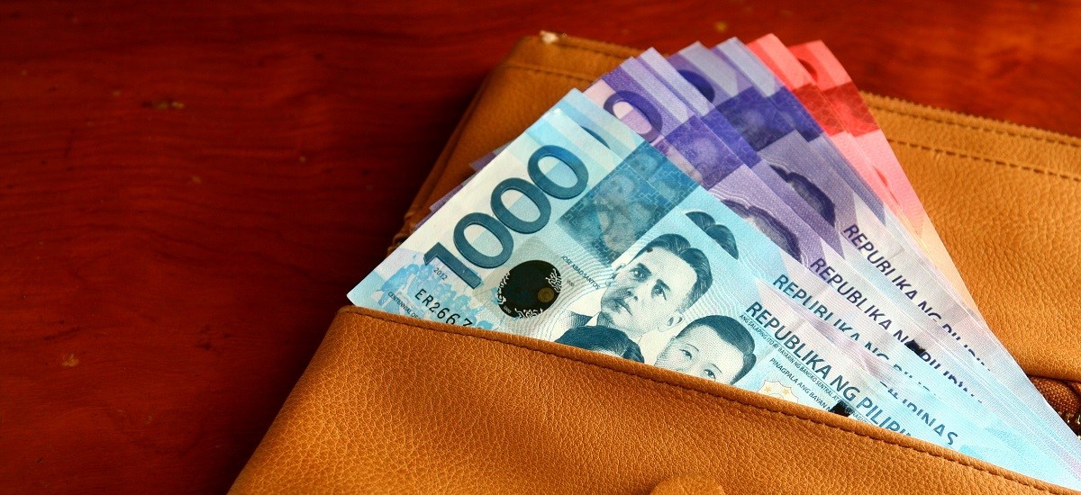 Close up of leather wallet full of Filippino Pesos