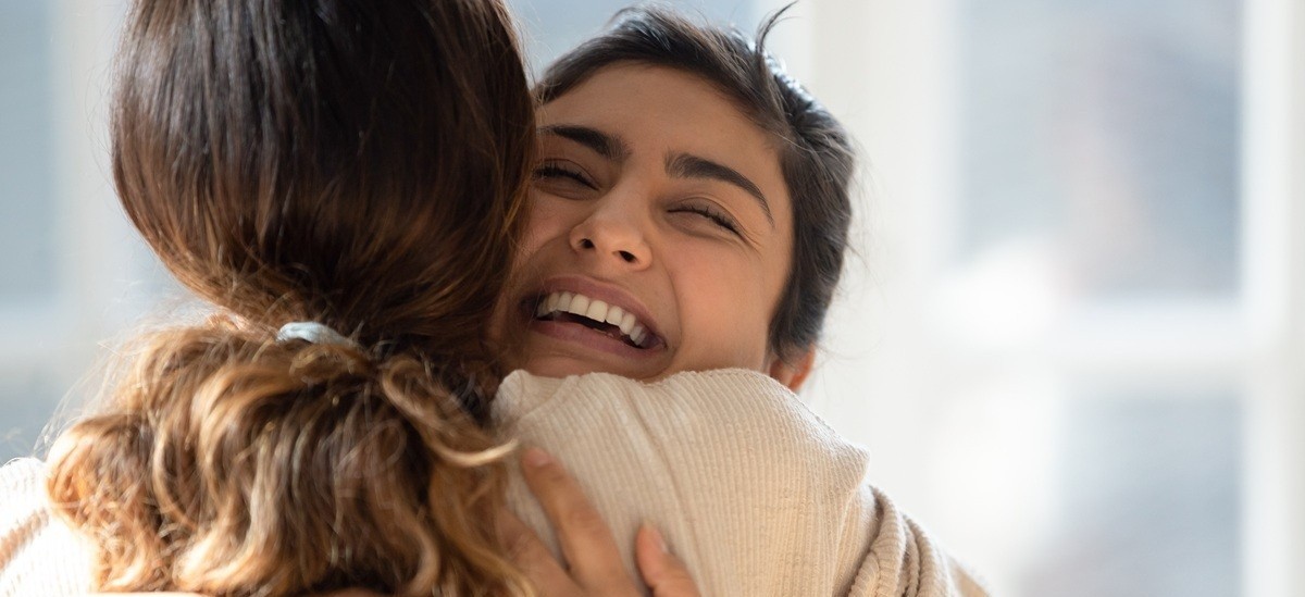 two women hugging and smiling