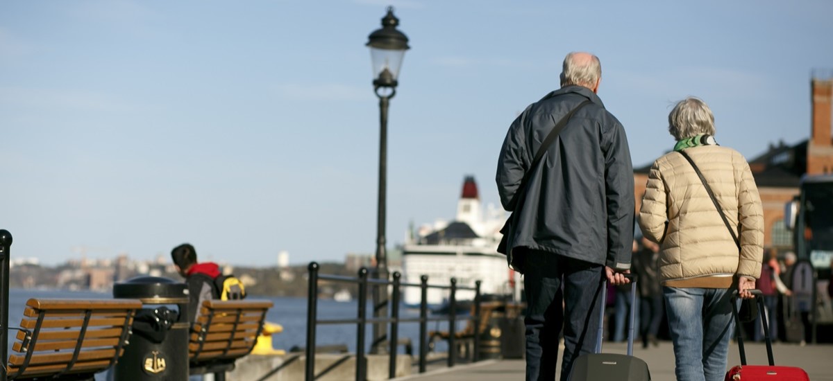 Elderly couple with suitcases walking in Stockholm, Sweden