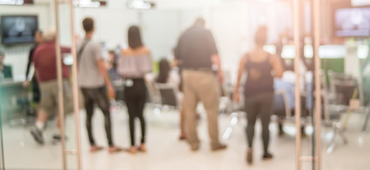 blurred-image-of-people-standing-in-line-at-bank