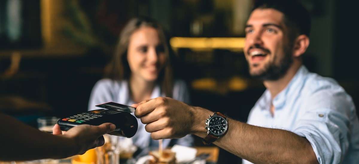 Couple using a card to pay for a meal in a restaurant