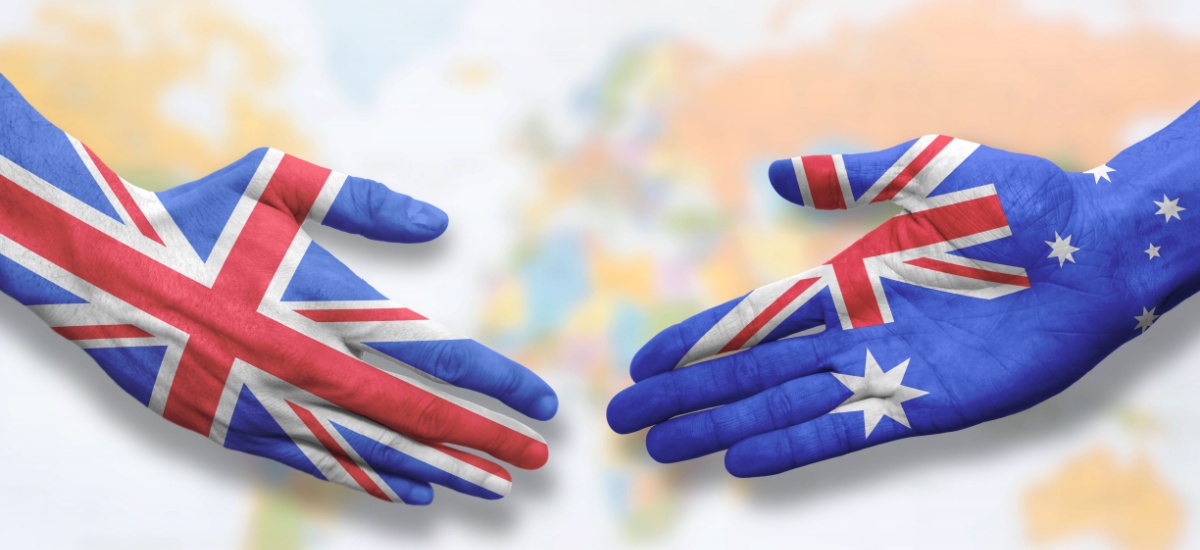 UK and Australia handshake with world map in background, each hand is painted like the flag