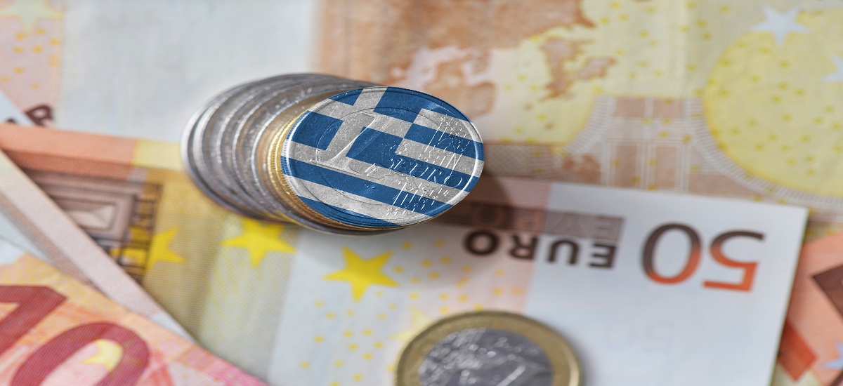 Euro coins and notes with one coin painted with Greek flag