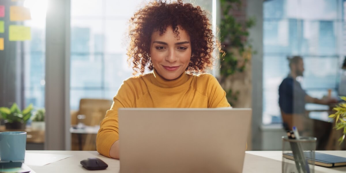 Eine Frau benutzt KI an ihrem Laptop