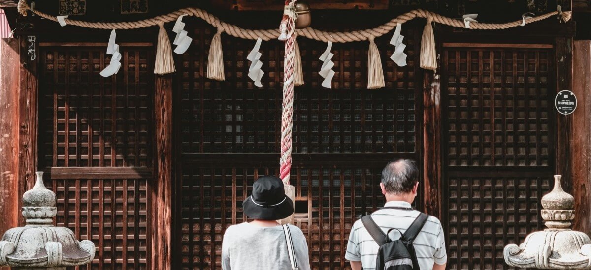 Couple praying at Japanese Shinto shrine
