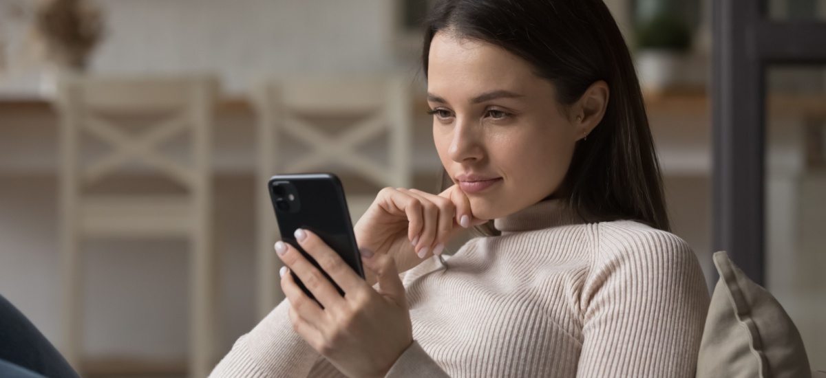 woman-thinking-and-looking-at-smartphone