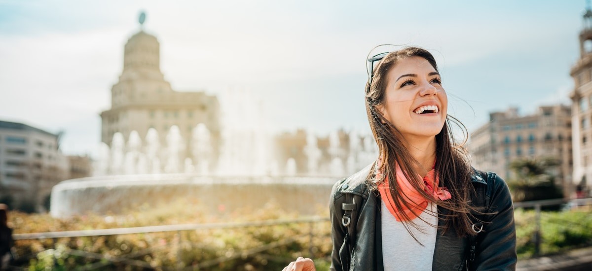 Young, brunette tourist in Barcelona, Spain, looking away from camera