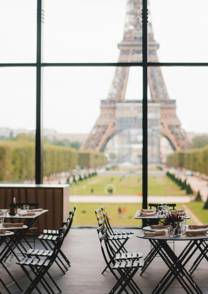 An empty restaurant, with a view of the Eiffel tower.