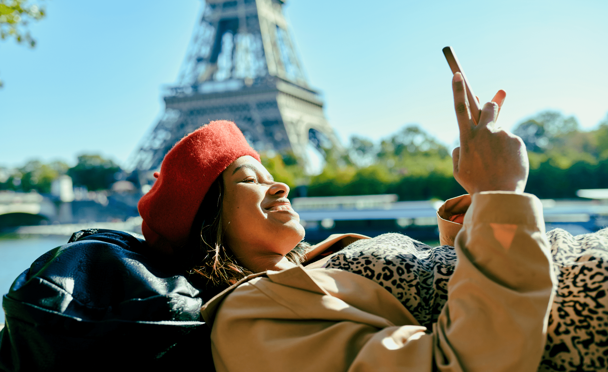 Woman on her phone in front of the Eiffel tower