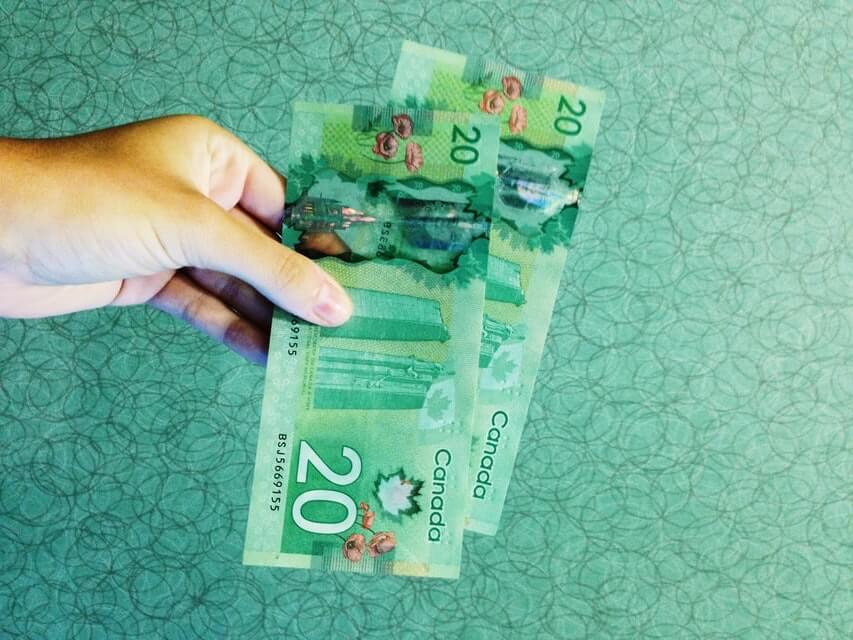 dlon_trzymajaca_dwa_banknoty_20_dolarow_kanadyjskich