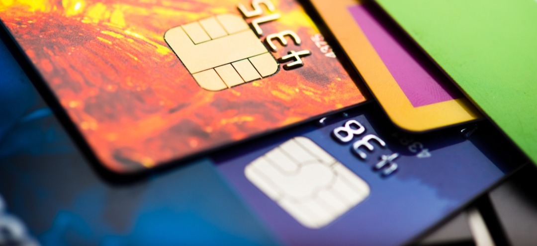Different colored credit cards laying on a surface