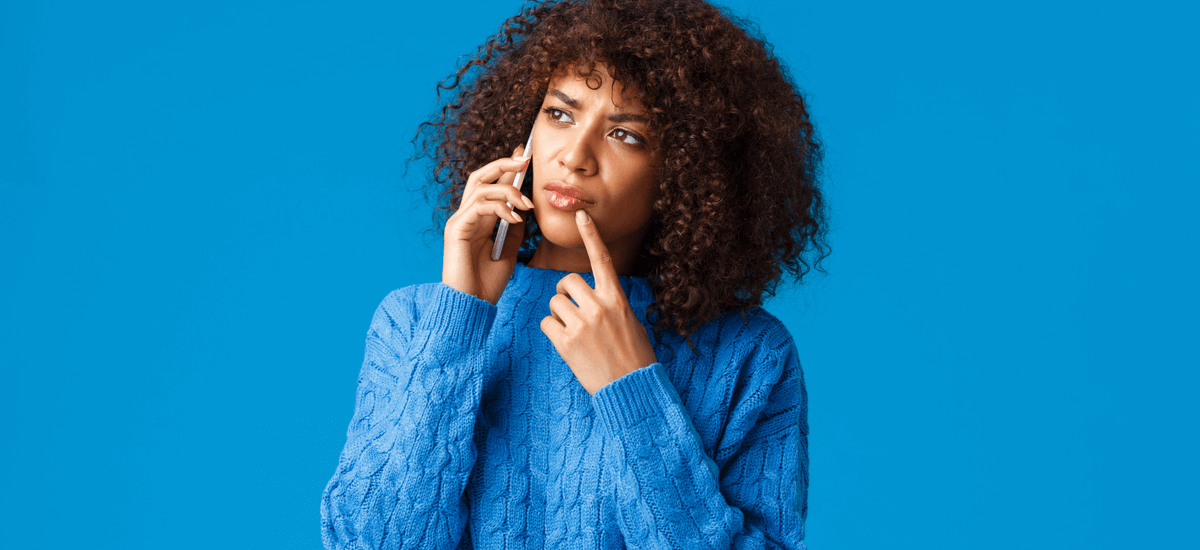woman-on-the-phone-thinking-blue-background