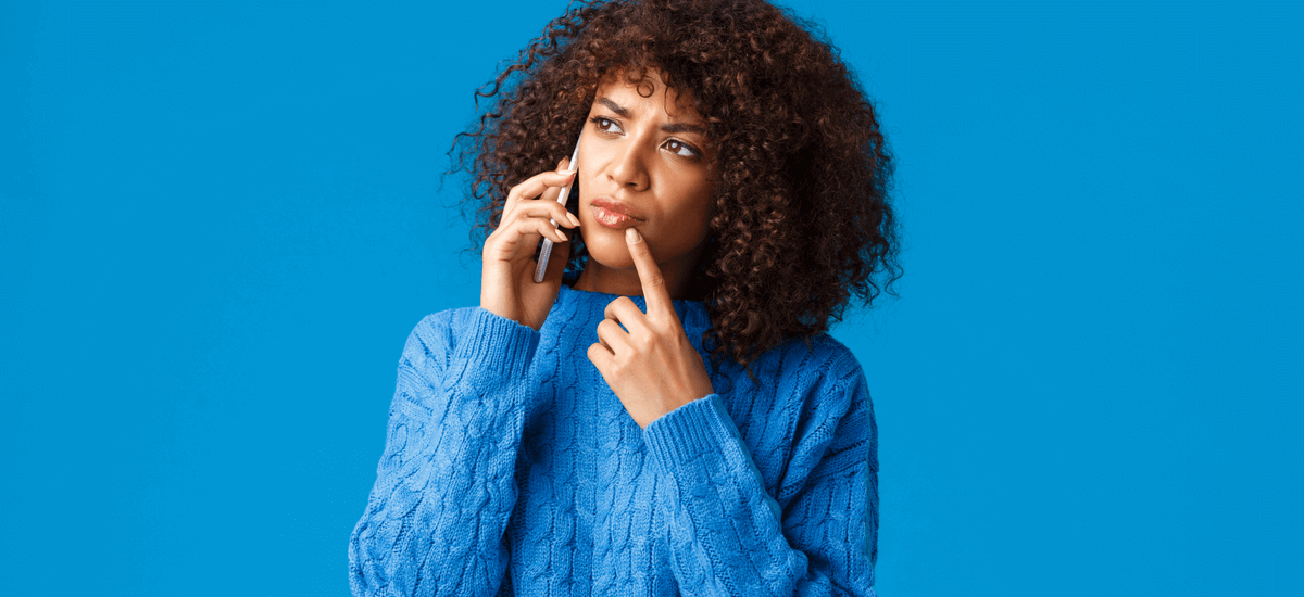 woman-on-the-phone-thinking-blue-background